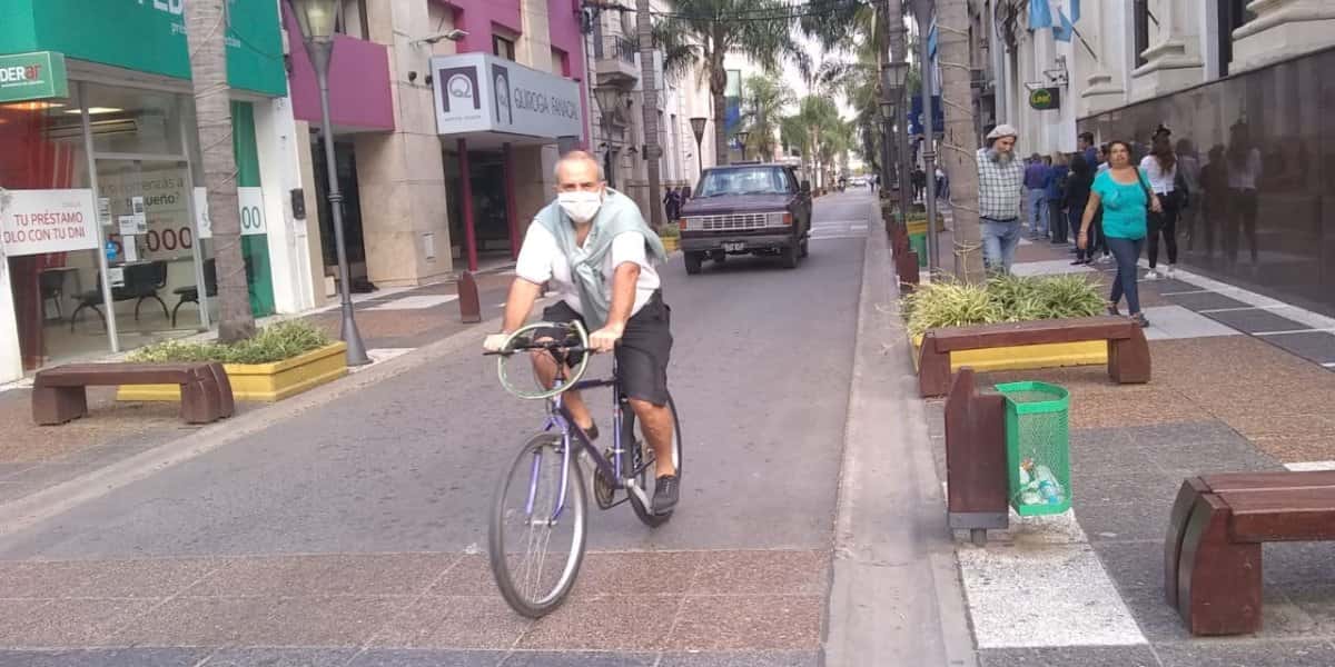Tapabocas. Un ciclista recorre la zona de bancos con su rostro cubierto. 