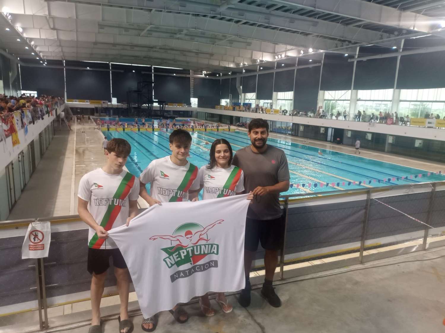 Bruno, Tobías, Maitena y el profesor Facundo en el imponente natatorio del Parque Olímpico.